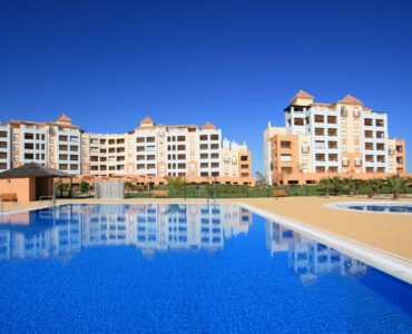 Gemeenschappelijk zwembad, vooraanzicht van nieuwbouw appartementen in Isla Canela in Spanje, gelegen aan de  Costa de la Luz