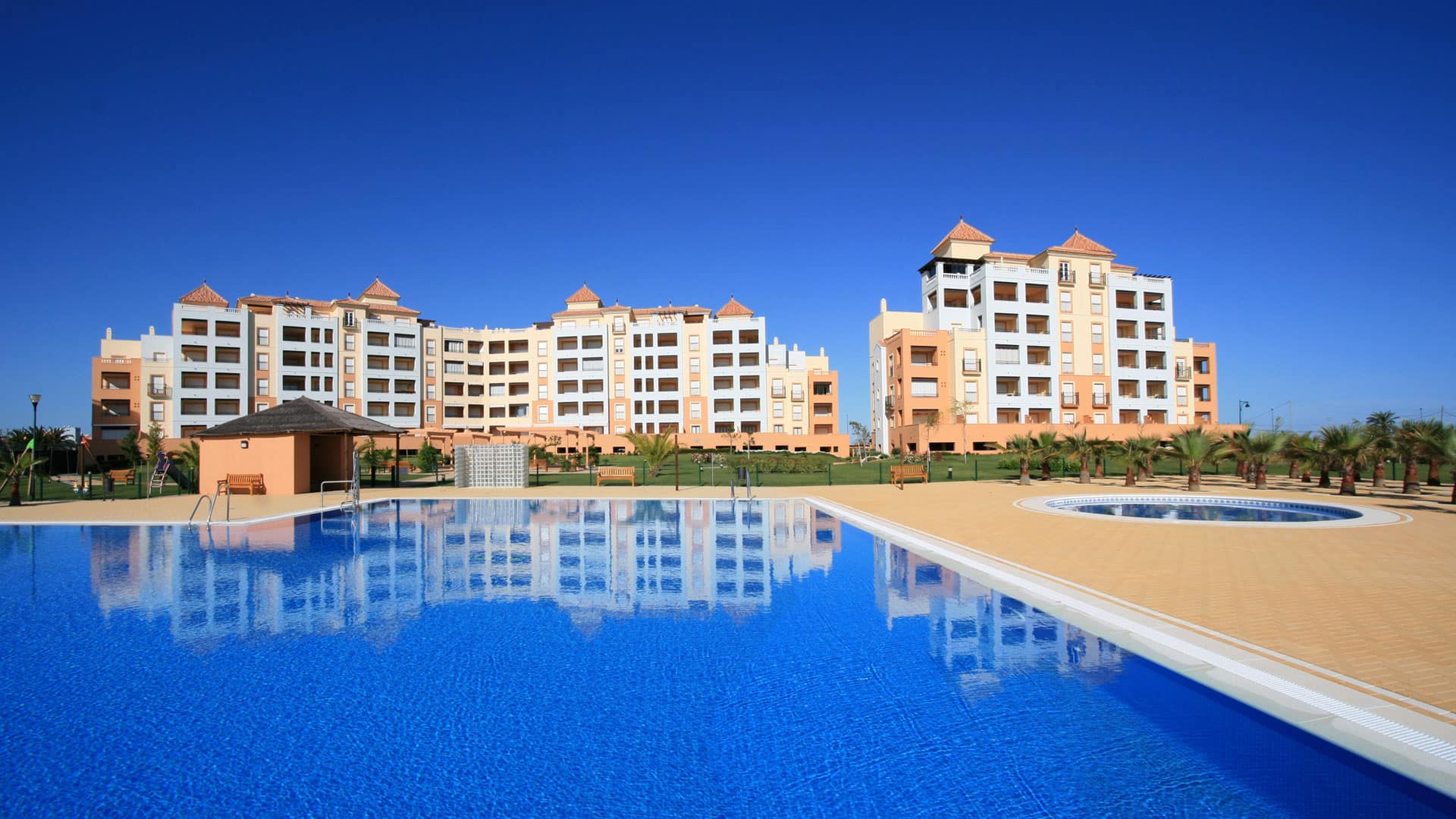 Gemeenschappelijk zwembad, vooraanzicht van nieuwbouw appartementen in Isla Canela in Spanje, gelegen aan de  Costa de la Luz