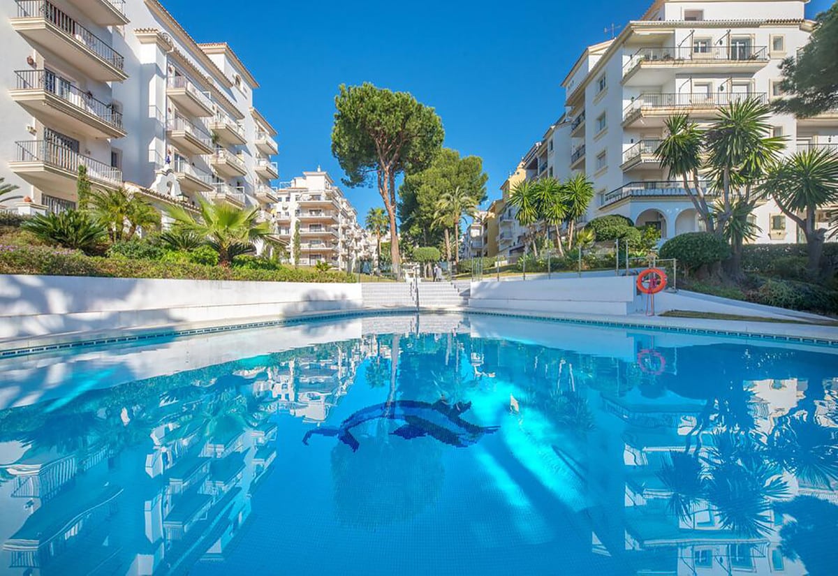 Gemeenschappelijk zwembad en vooraanzicht van resale appartementen in Nueva Andalucia in Spanje, gelegen aan de  Costa del Sol-West