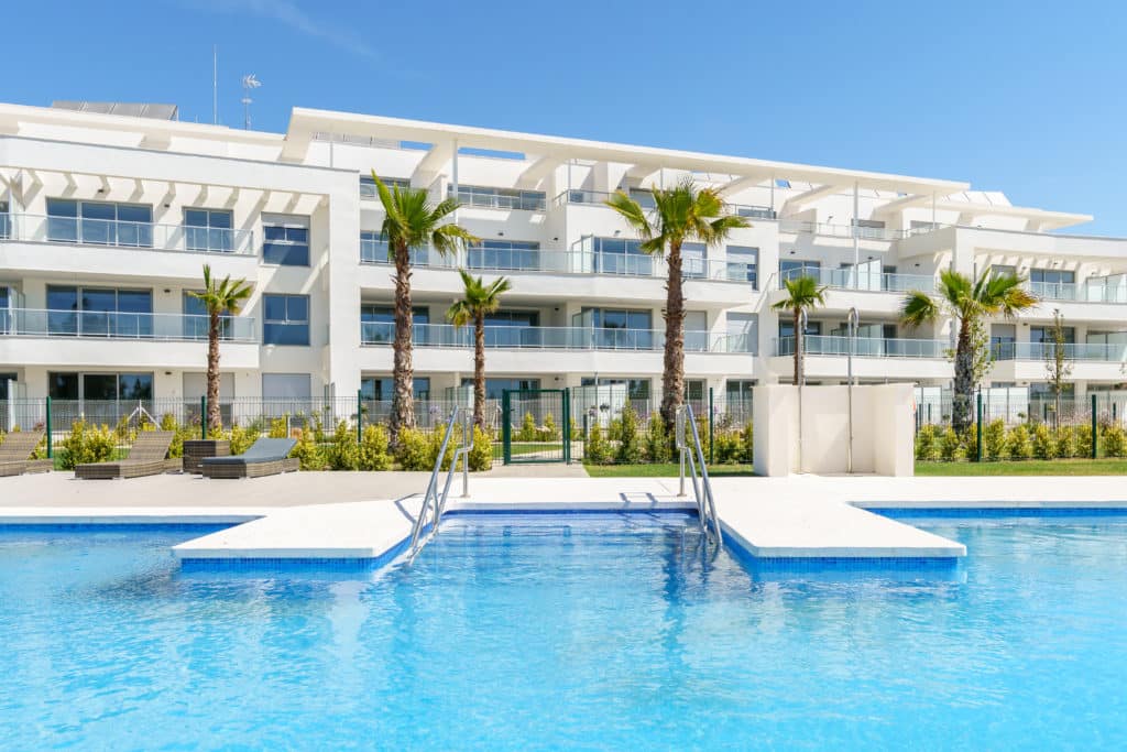 Gemeenschappelijk zwembad en vooraanzicht van nieuwbouw appartement in Mijas Costa in Spanje, gelegen aan de  Costa del Sol-Centro