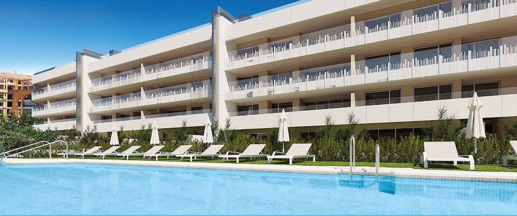Gemeenschappelijk zwembad en vooraanzicht van nieuwbouw appartement in San Pedro Alcantara in Spanje, gelegen aan de  Costa del Sol-West