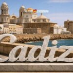 Cadiz aan het water met een stenen standbeeld met de naam Cadiz op de voorgrond.